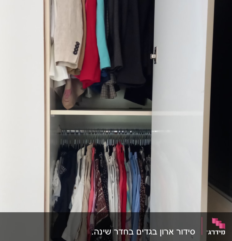 ארון בגדים מסודר עם חליפות וחולצות על קולבים